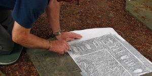 Volunteer Martin Broadbent carries out a gravestone rubbing as part of a project documenting the stones in St Mary's Old Churchyard.